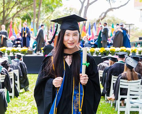 一名学生在毕业典礼上拿到毕业证书后回到座位上.