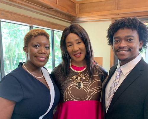 Two students pose with political campaign strategist Mo Ellei的e.